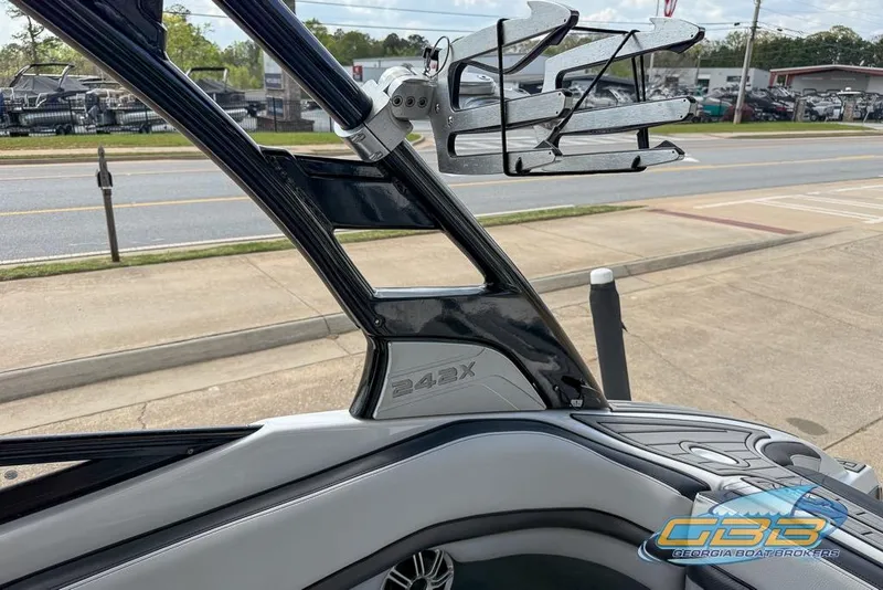 Slide: The Image of 2017 Yamaha Boats 242X E-Series interior with wakeboard rack, parked near a road. - 44