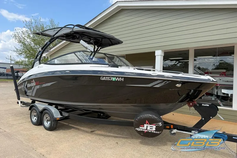 Slide: The Image of 2017 Yamaha Boats 242X E-Series on trailer, sleek black design, parked outside dealership. - 8