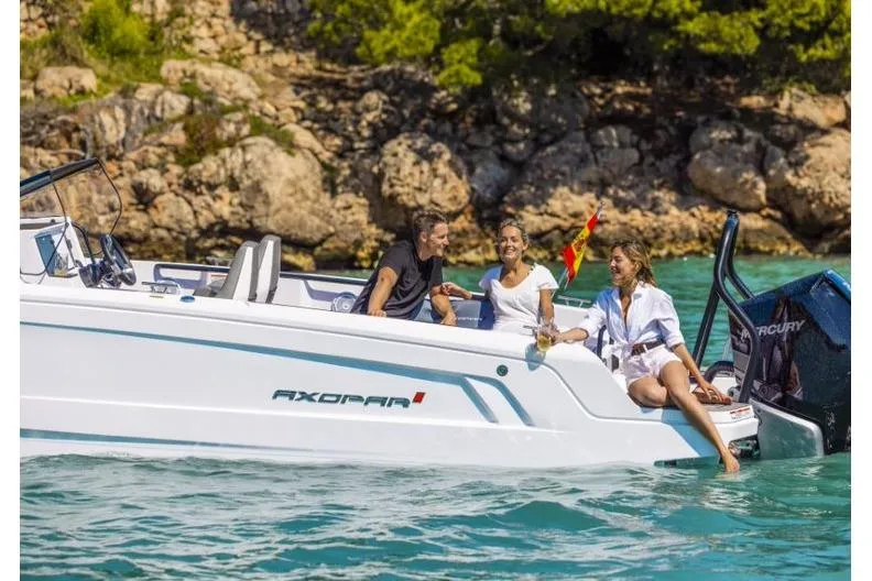Slide: The Image of 2027 Axopar 25 Cross Bow with people enjoying a sunny day on the water. - 3