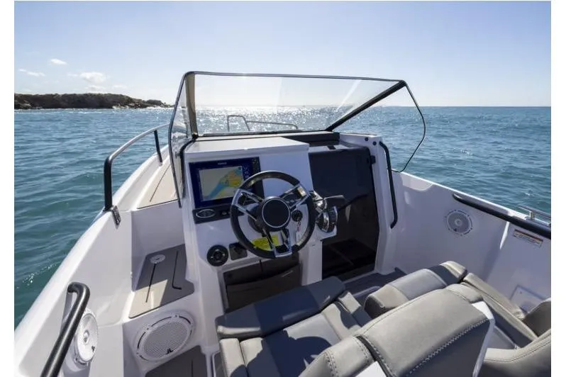 Slide: The Image of 2027 Axopar 25 Cross Bow boat interior with steering wheel and navigation system. - 6