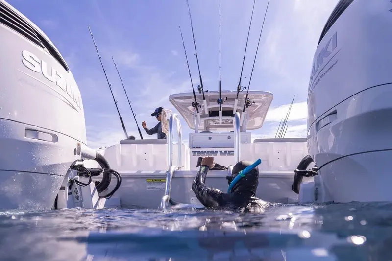 Slide: The Image of Diver climbing onto Twin Vee 280 GFX2 CC boat, 2026 model. - 3