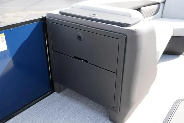 Slide: The Image of 2026 Harris Sunliner 230 boat interior storage compartment with sleek design and modern seating. - 15
