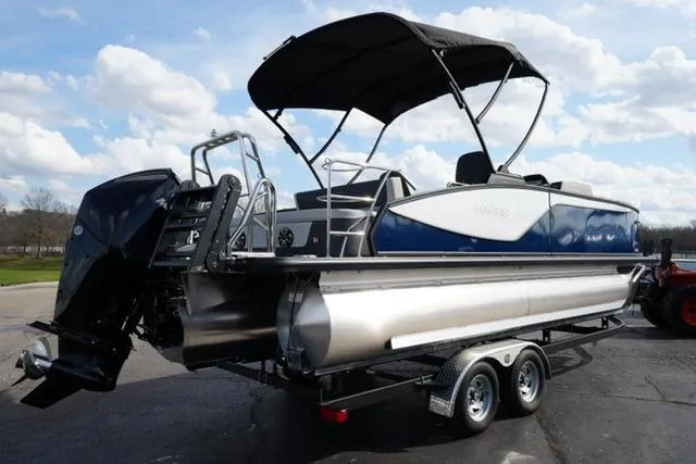 Slide: The Image of 2026 Harris Sunliner 230 pontoon boat on trailer, featuring a sleek design and canopy. - 5