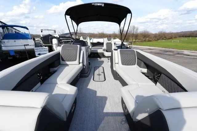 Slide: The Image of 2026 Harris Sunliner 230 pontoon boat with spacious seating and canopy, parked outdoors. - 7
