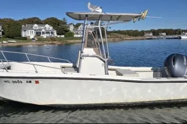 Slide: The Image of 1987 Mako 212 Center Console boat on calm water near coastal homes. - 4