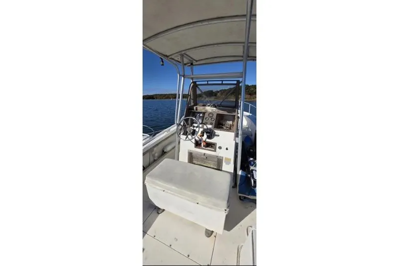 Slide: The Image of 1987 Mako 212 Center Console boat interior with steering wheel and controls on a sunny day. - 7