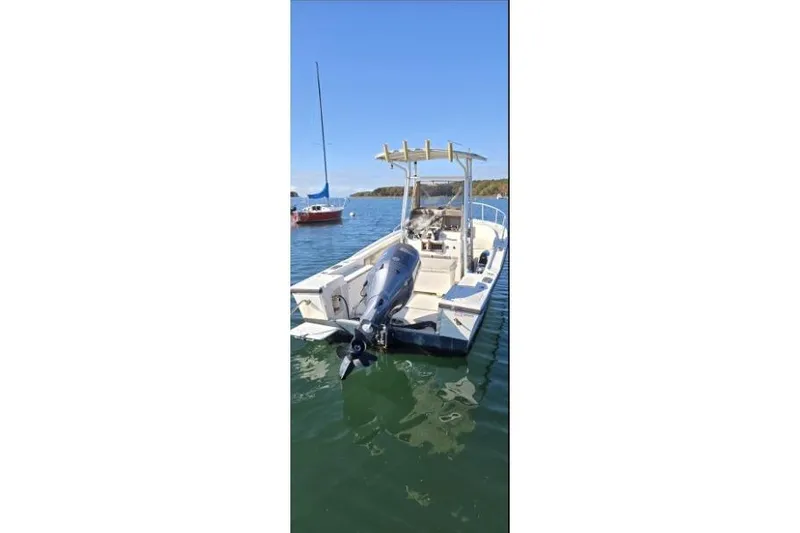 Slide: The Image of 1987 Mako 212 Center Console boat on calm water, featuring an outboard motor. - 8