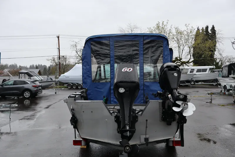 Slide: The Image of 2005 Alumaweld Talon 17 boat with dual outboard motors in a parking lot. - 4