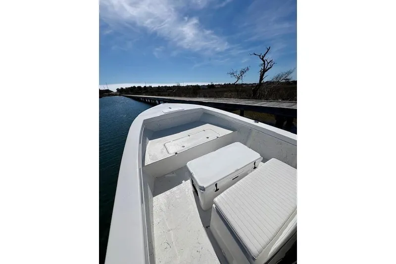 Slide: The Image of 2025 C-Hawk 26 Center Console boat on calm water under a clear blue sky. - 10