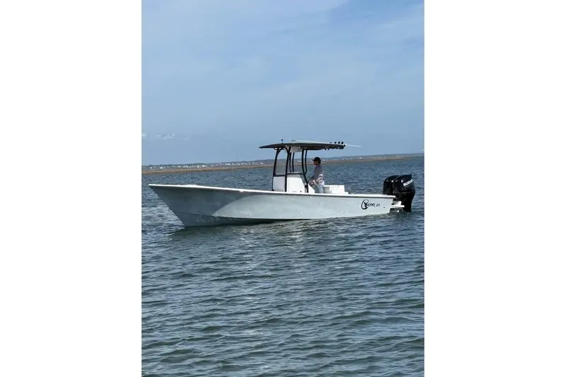 Slide: The Image of 2025 C-Hawk 26 Center Console boat on calm water under clear sky. - 2