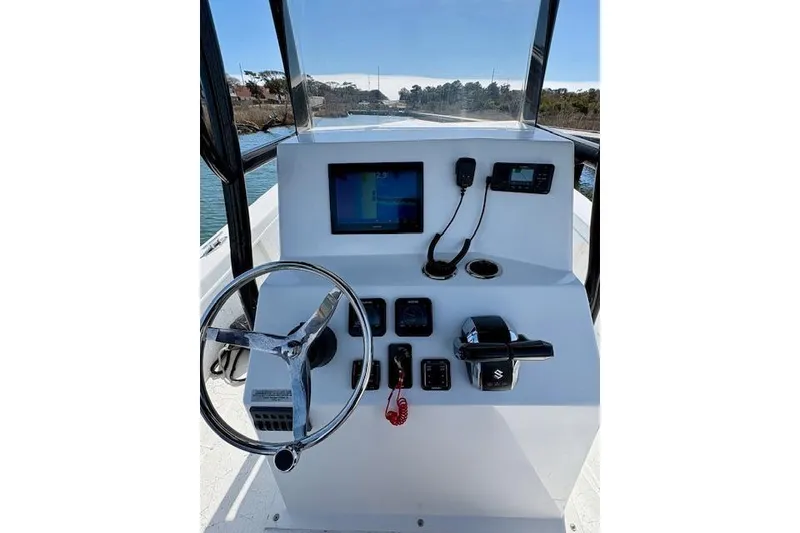 Slide: The Image of 2025 C-Hawk 26 Center Console boat dashboard with steering wheel and navigation controls. - 4