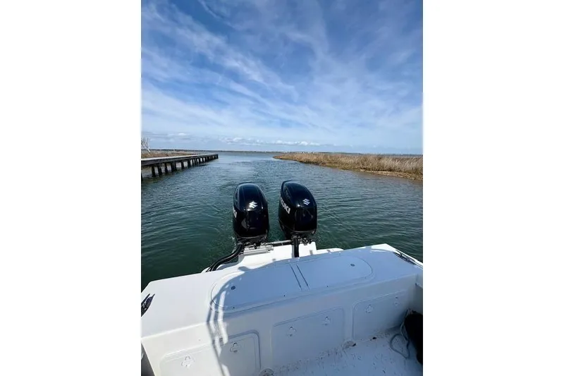 Slide: The Image of 2025 C-Hawk 26 Center Console boat with dual engines on a serene waterway. - 5