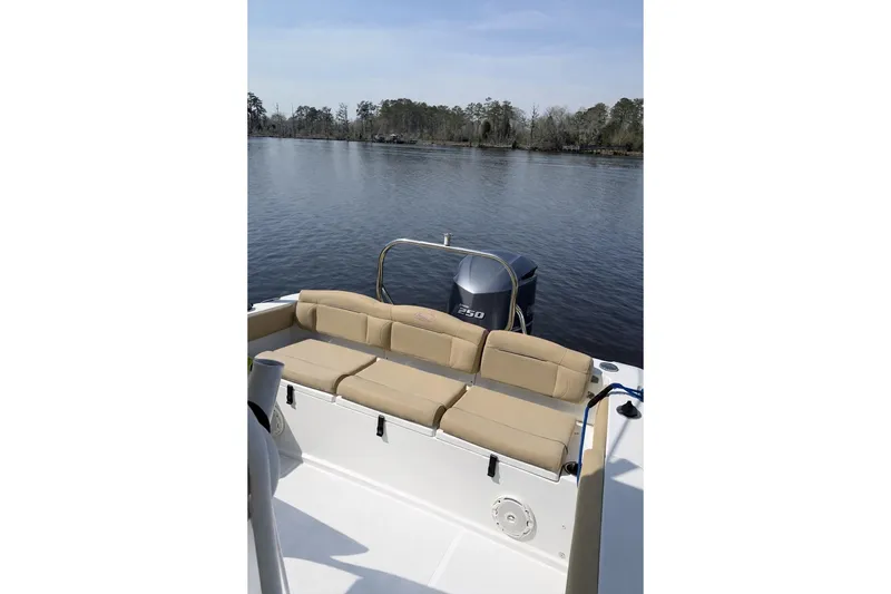Slide: The Image of 2018 Sea Hunt Ultra 234 boat with beige seating, on a calm lake. - 4