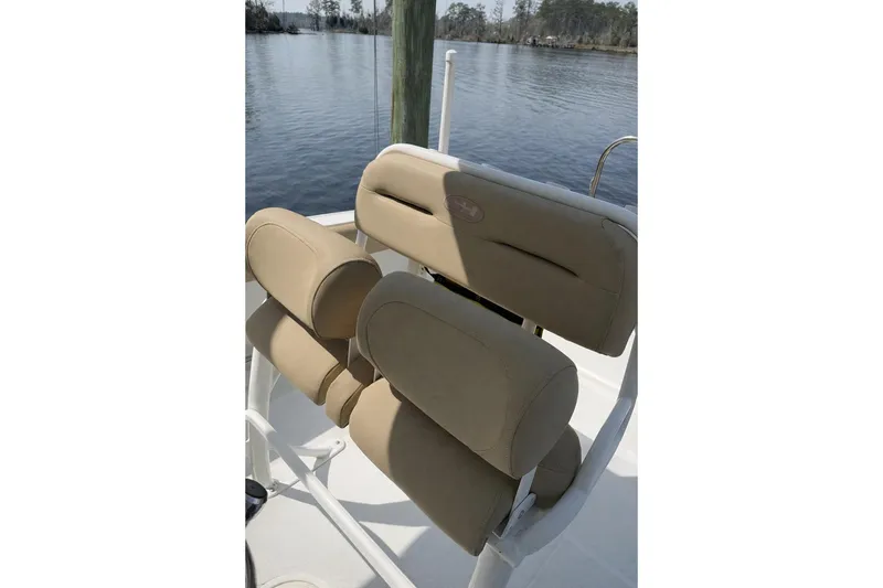 Slide: The Image of 2018 Sea Hunt Ultra 234 boat seats with tan upholstery, overlooking calm water. - 5