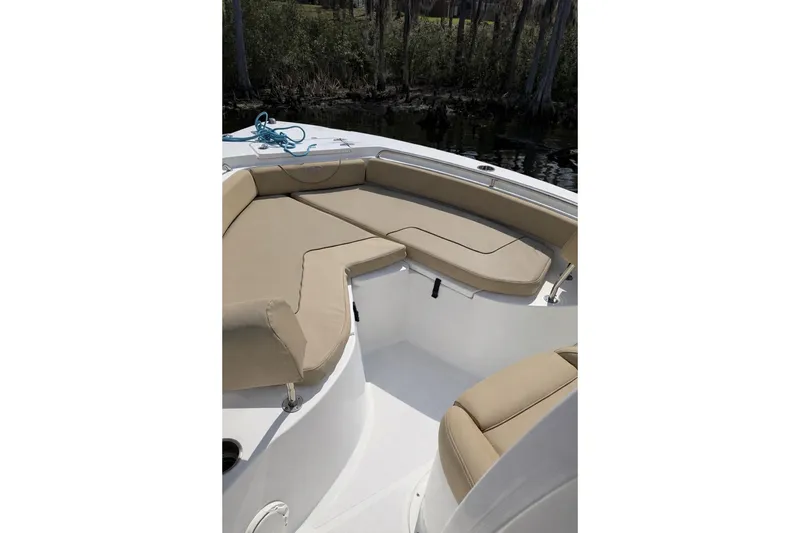 Slide: The Image of 2018 Sea Hunt Ultra 234 boat with beige seating, docked near trees. - 6