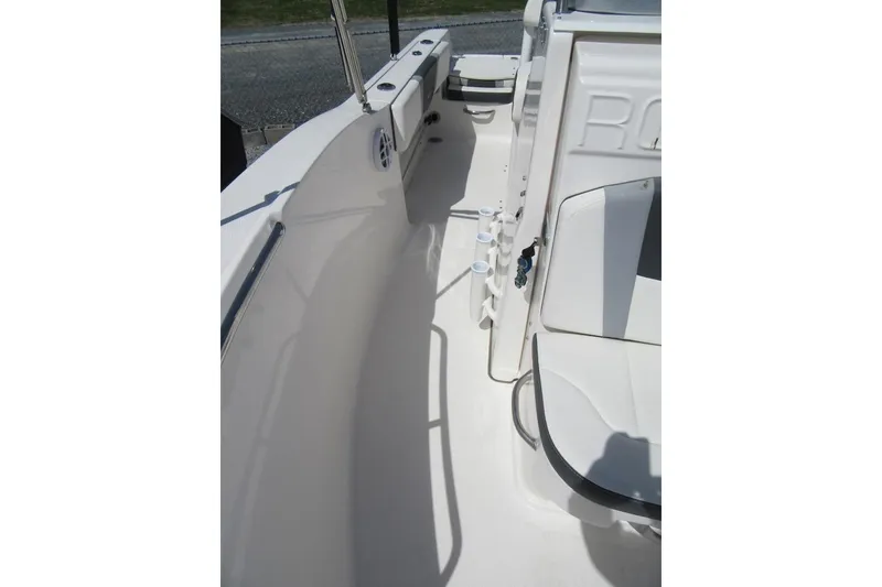 Slide: The Image of 2023 Robalo R180 Center Console boat interior, featuring sleek white seating and storage compartments. - 11