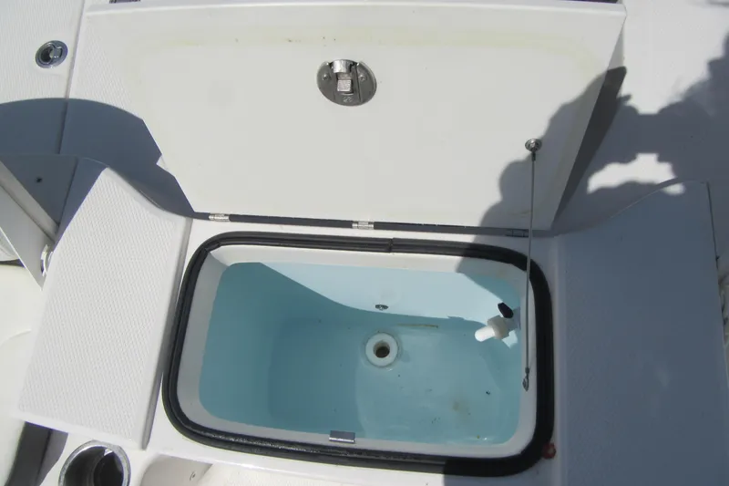 Slide: The Image of 2023 Robalo R180 Center Console livewell with open lid, showcasing interior design. - 18
