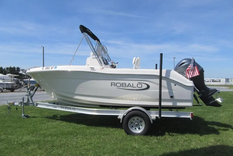 Slide: The Image of 2023 Robalo R180 Center Console boat on trailer, displayed outdoors. - 2