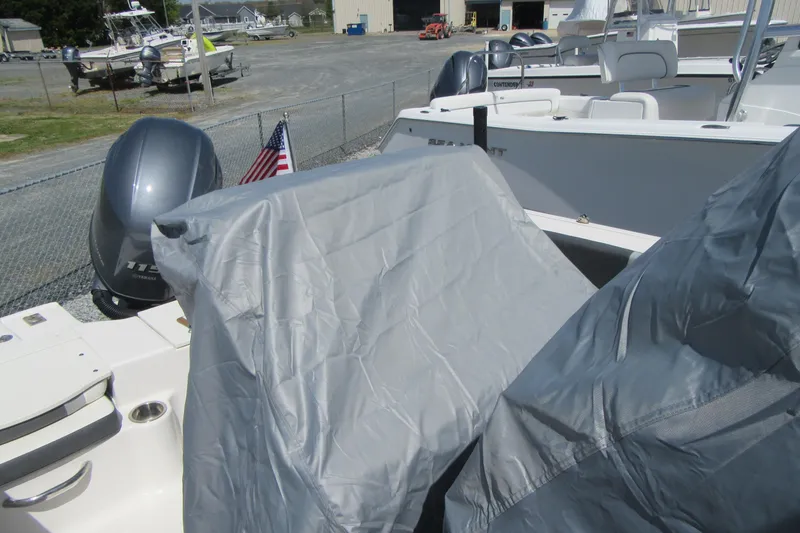 Slide: The Image of 2023 Robalo R180 Center Console boat with covered seats and outboard motor. - 23