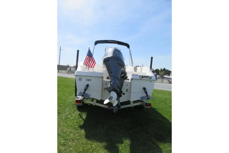 Slide: The Image of 2023 Robalo R180 Center Console boat with outboard motor and American flag. - 3