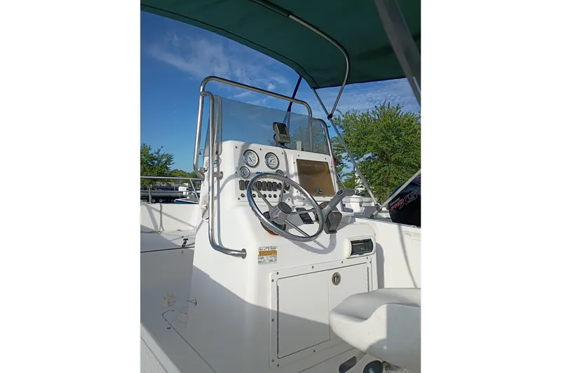 Slide: The Image of 2002 Sea Pro 190 Center Console boat interior with steering wheel and gauges under blue sky. - 4