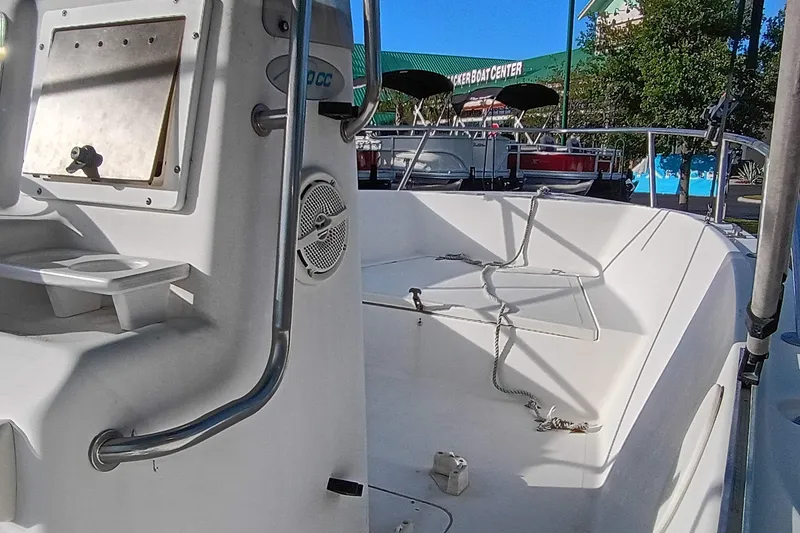 Slide: The Image of 2002 Sea Pro 190 Center Console boat interior with seating and storage, docked at a marina. - 6