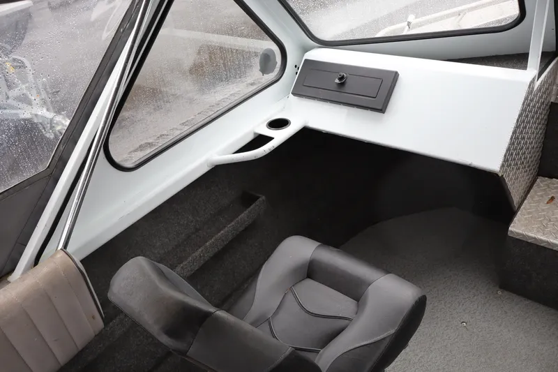 Slide: The Image of Interior of 2006 Thunder Jet Luxor 19 boat, featuring seating and dashboard area. - 8