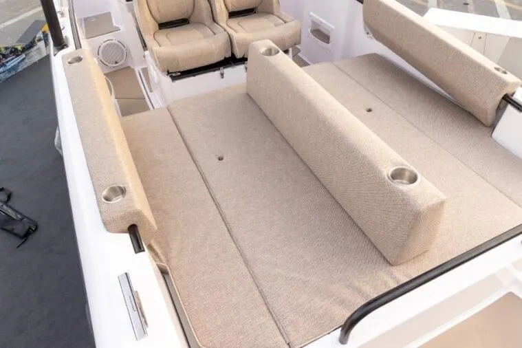 Slide: The Image of 2027 Axopar 25 Cross Top boat interior with beige seating and cup holders. - 3
