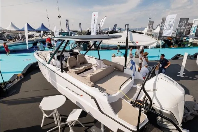 Slide: The Image of 2027 Axopar 25 Cross Top boat displayed at a marine exhibition. - 6