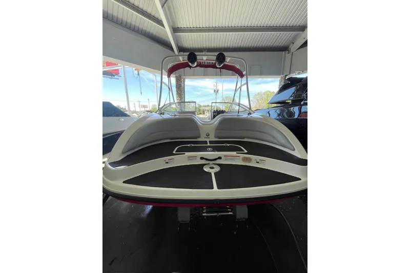 Slide: The Image of 2008 Yamaha Boats AR210 in showroom, rear view showcasing sleek design and seating area. - 11
