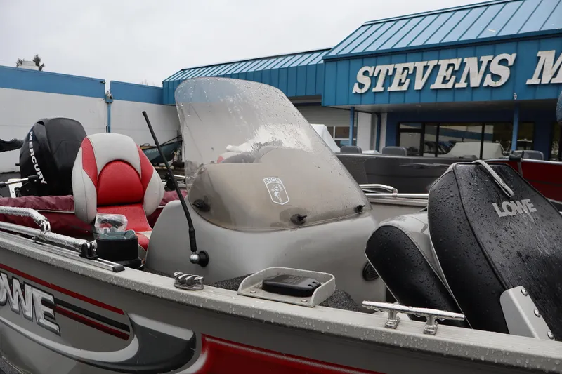 Slide: The Image of 2009 Lowe Fishing Machine 165 boat at Stevens Marine dealership, featuring red and gray seating. - 12