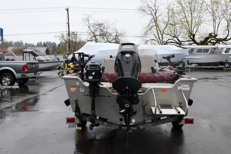Slide: The Image of 2009 Lowe Fishing Machine 165 boat with motor in a wet parking lot. - 4
