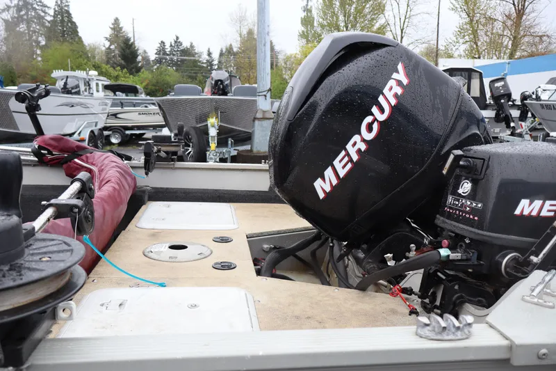 Slide: The Image of 2009 Lowe Fishing Machine 165 with Mercury outboard motor in a boatyard setting. - 7