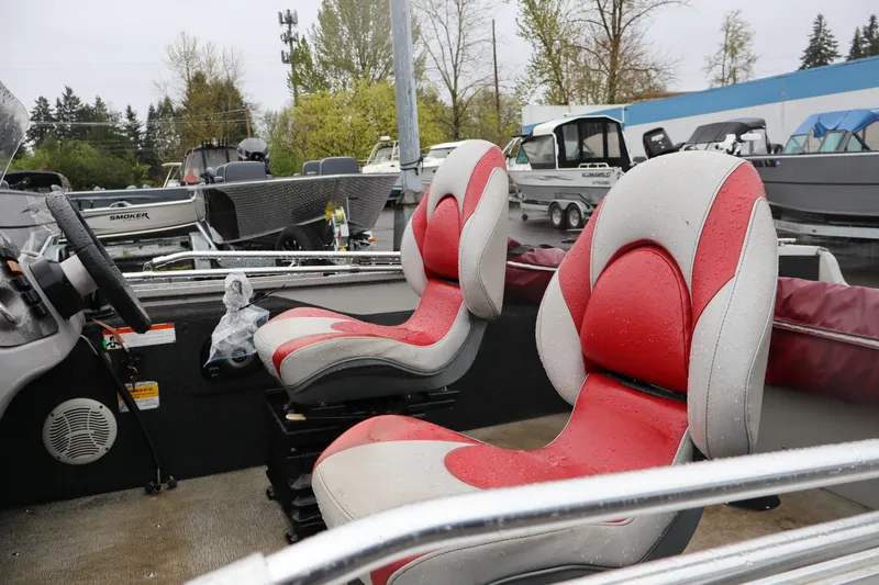 Slide: The Image of 2009 Lowe Fishing Machine 165 interior with red and gray seats, wet from rain. - 9