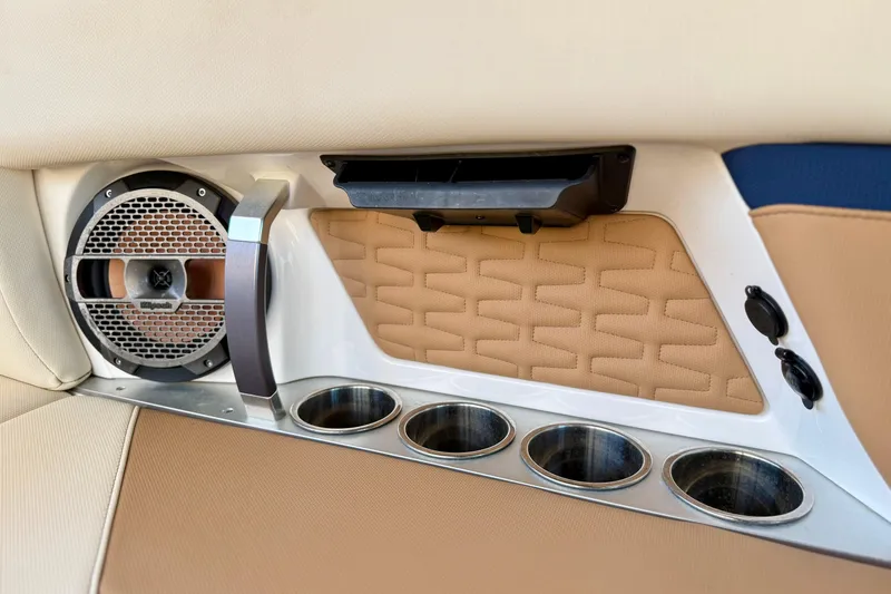 Slide: The Image of Interior of 2022 MasterCraft X24 boat with speaker, cup holders, and beige upholstery. - 36
