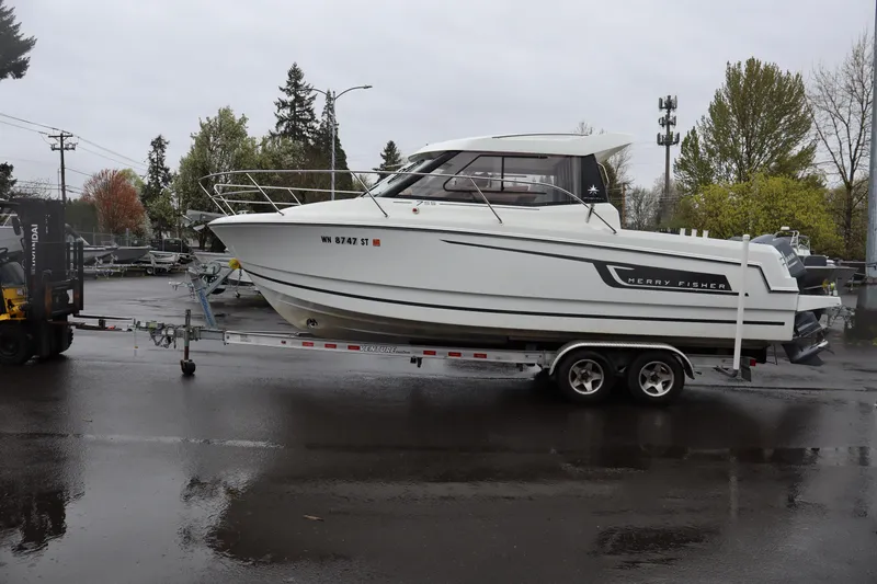 The Image of 2015 Jeanneau Merry Fisher 755 boat on trailer in parking lot. - 1