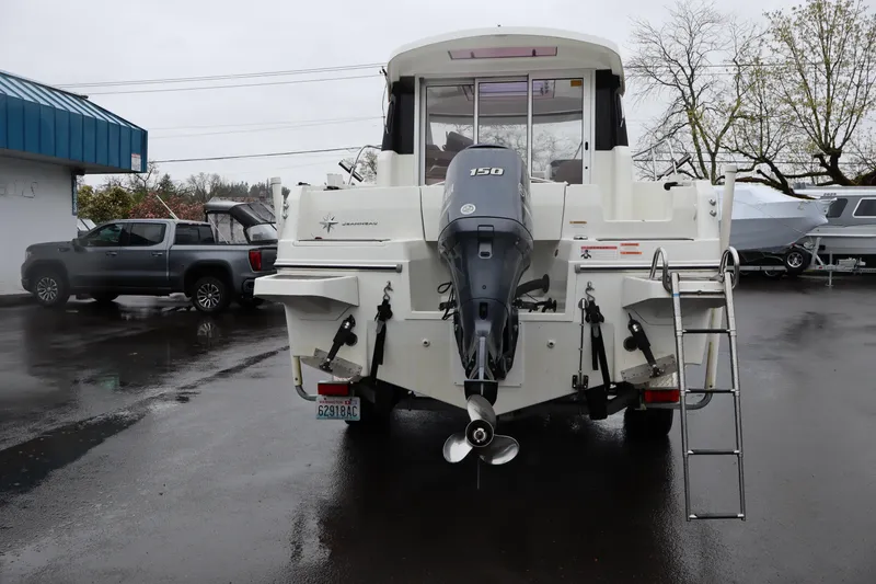 Slide: The Image of 2015 Jeanneau Merry Fisher 755 boat with outboard motor and ladder, parked outdoors. - 4