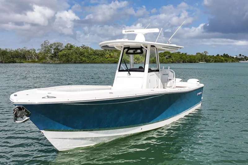 The Image of 2020 Regulator 31 boat on calm water with lush green shoreline. - 0