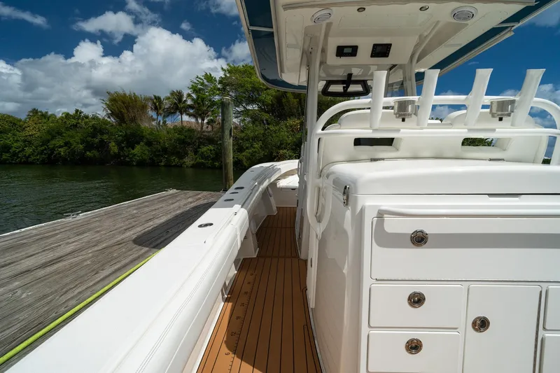 Slide: The Image of 2020 Regulator 31 boat docked, featuring sleek white design and spacious deck under blue sky. - 10