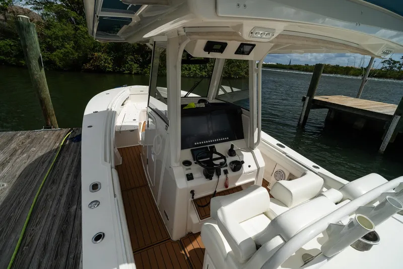 Slide: The Image of 2020 Regulator 31 boat interior with helm, docked by a wooden pier. - 12