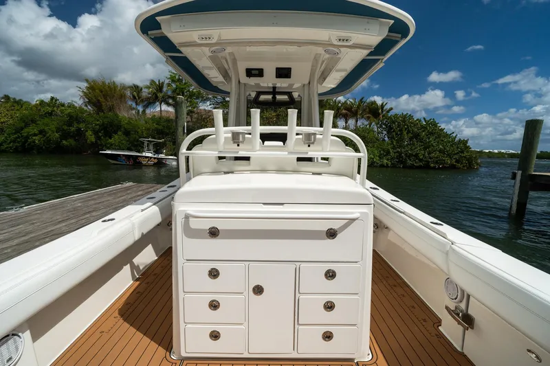 Slide: The Image of 2020 Regulator 31 boat interior with storage drawers, docked by lush greenery and calm waters. - 15