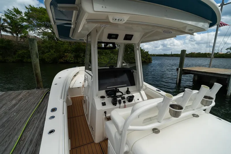 Slide: The Image of 2020 Regulator 31 boat interior with helm, rod holders, and water view. - 18