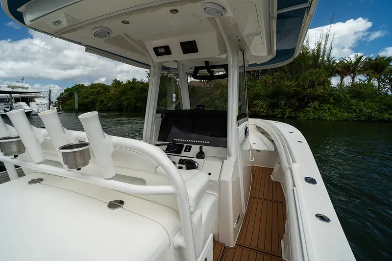 Slide: The Image of 2020 Regulator 31 boat interior with helm, rod holders, and scenic waterway view. - 20