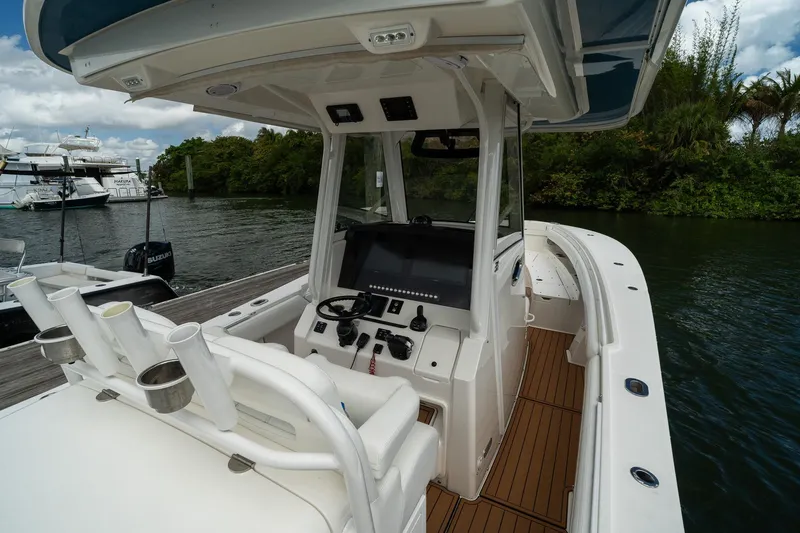 Slide: The Image of 2020 Regulator 31 boat interior with helm, rod holders, and water view. - 21