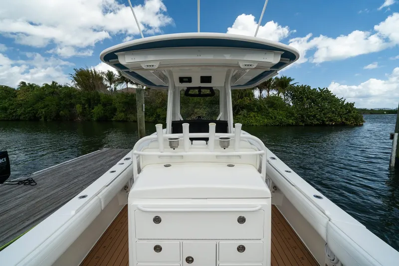 Slide: The Image of 2020 Regulator 31 boat interior with helm station, docked by lush greenery and calm waters. - 24