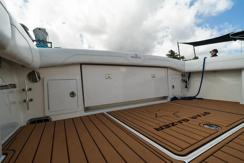 Slide: The Image of 2020 Regulator 31 boat deck with teak flooring and storage compartments under a cloudy sky. - 26