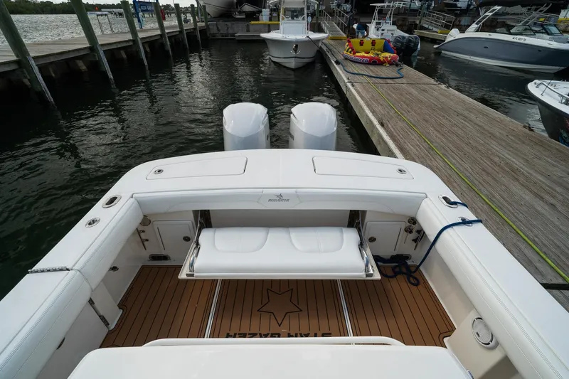 Slide: The Image of 2020 Regulator 31 boat docked, featuring spacious seating and dual engines. - 33