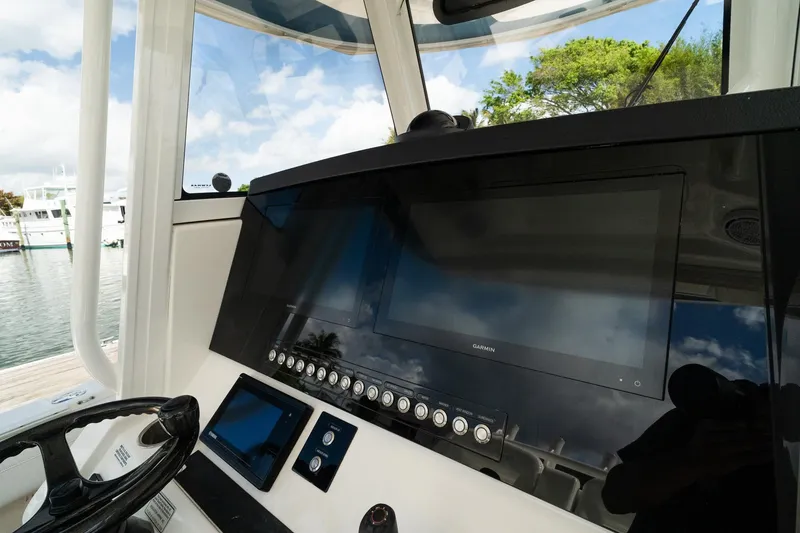 Slide: The Image of 2020 Regulator 31 boat dashboard with Garmin navigation system, docked by the water. - 37