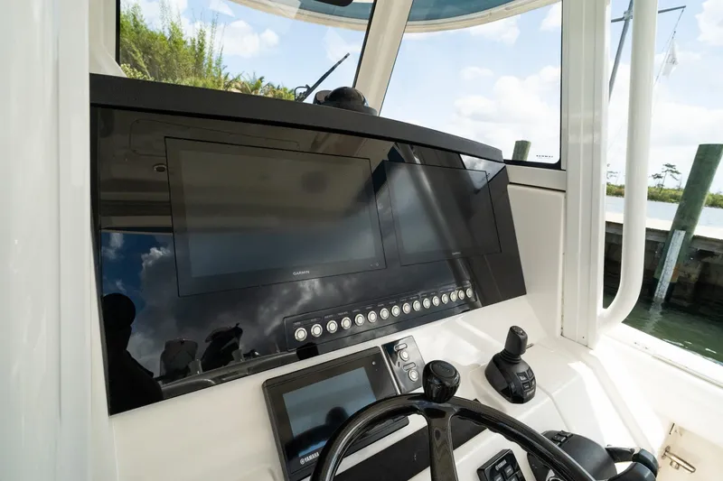 Slide: The Image of 2020 Regulator 31 boat dashboard with Garmin displays and steering wheel. - 39