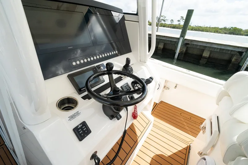 Slide: The Image of 2020 Regulator 31 boat helm with modern controls and teak flooring. - 40